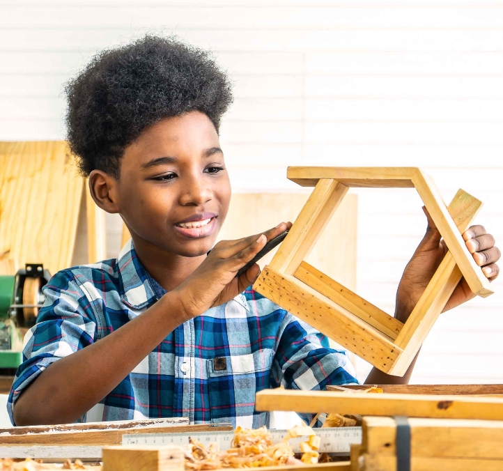 young boy making a toy wooden house