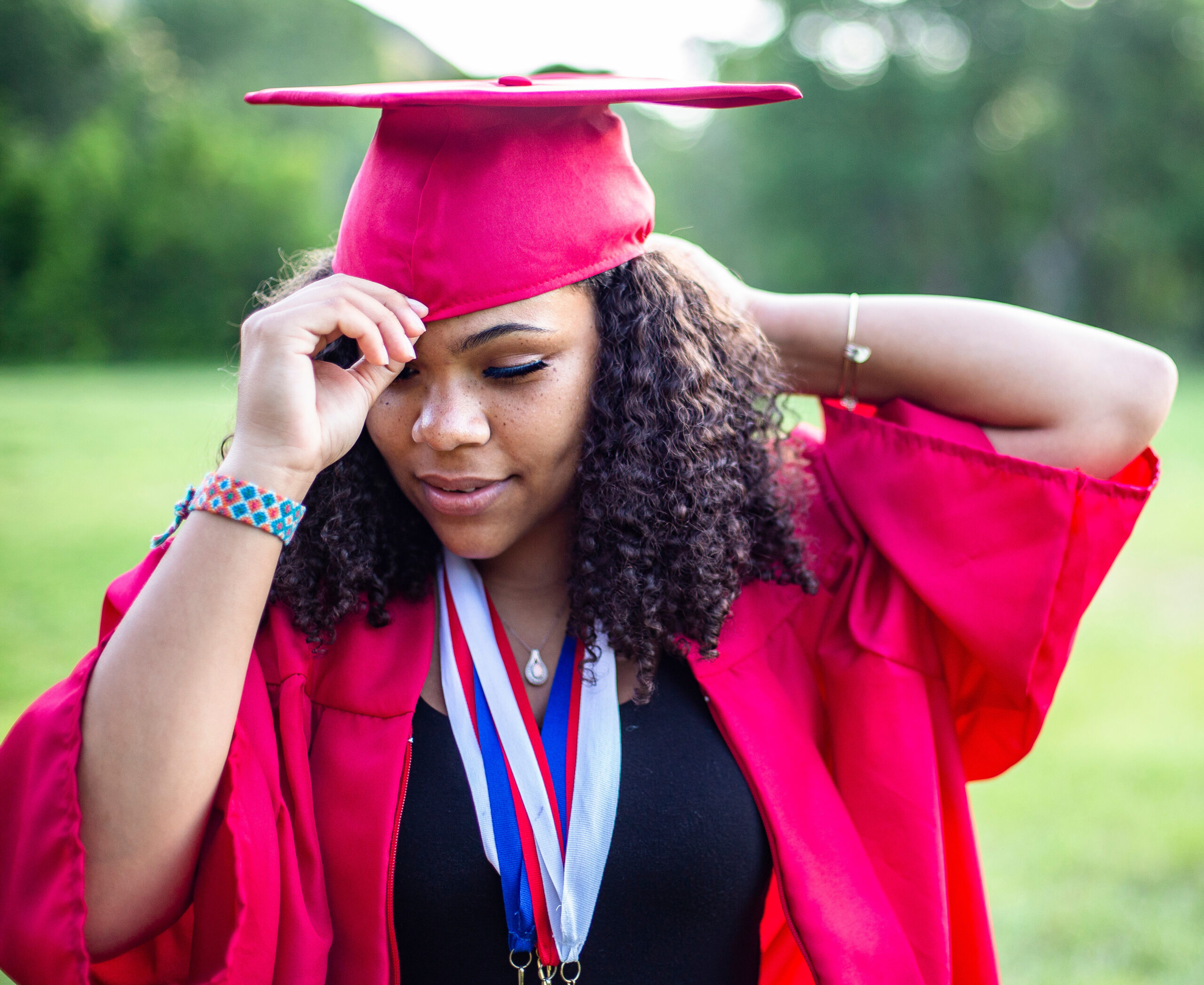 A high school senior putting on her graduation cap.